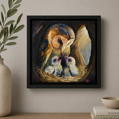 Framed artwork of an owl and chicks on a wall above a wooden shelf with decor items.