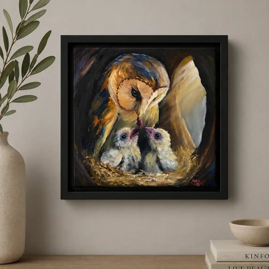 Framed artwork of an owl and chicks on a wall above a wooden shelf with decor items.