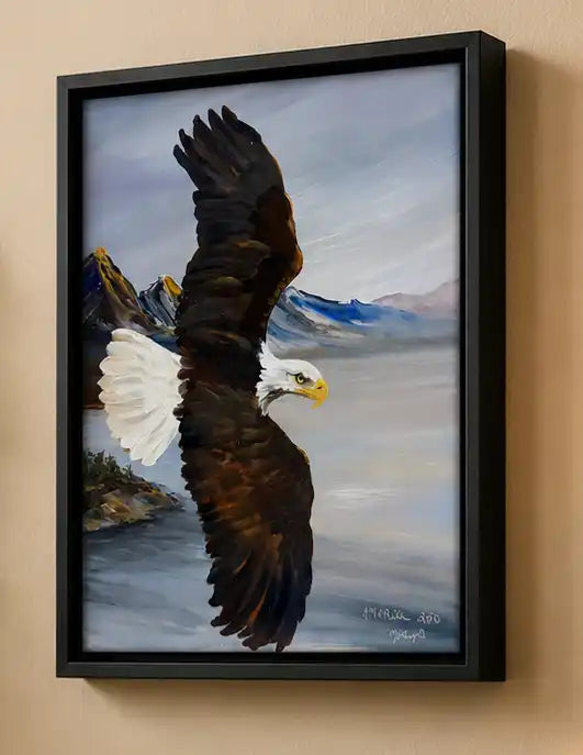 Framed painting of an eagle flying over water with mountains in the background. Molly's Fine Art