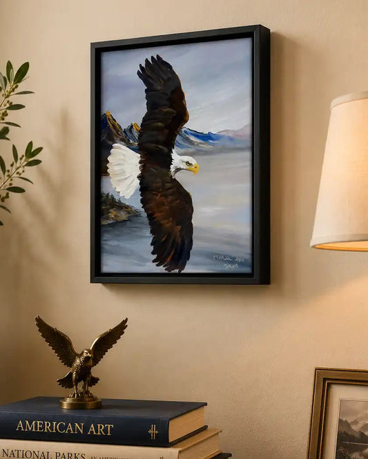 Framed Original artwork of a Bald Eagle on a wall above books with decorative items. Molly's Fine Art